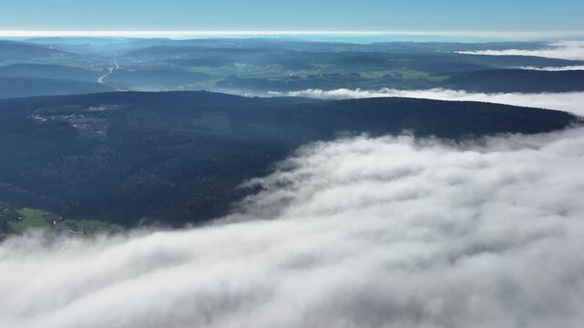 Aerial view of a stunning cloudscape drifting over dark forests and rolling hills, creating a mesmerizing contrast of light and shadow, Eichenzell, Hessen, Germany.