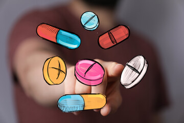 Hand points at colorful pills and capsules.  Medical, pharmacy, healthcare concept.