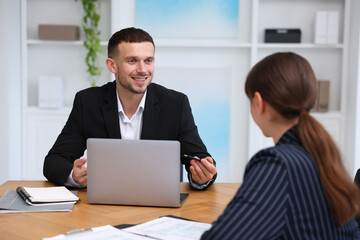 Consultant working with client at table in office. Business meeting