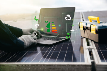 Engineer man using laptop on solar panels with energy efficiency rating.