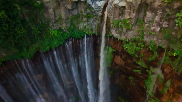 Tumpak Sewu waterfall, East Java, framed by lush cliffs and Semeru's shadow