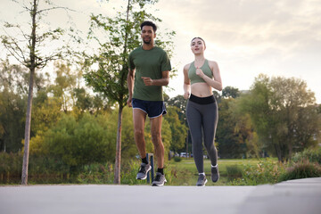 Fototapeta premium Sporty couple running outdoors, low angle view