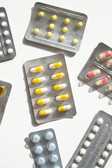 Various medicine pill and capsule blister packs on white surface.