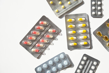 Various medicine blister packs with pills and capsules on white. Healthcare and pharmacy assortment.