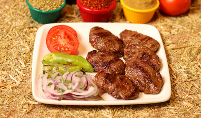 a serving of grilled meatballs on a white plate