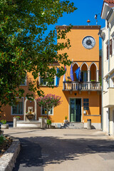 Municipal Building (Town Hall) in moscenicka draga, Croatia with a clock tower, flags, fountain, and Mediterranean atmosphere