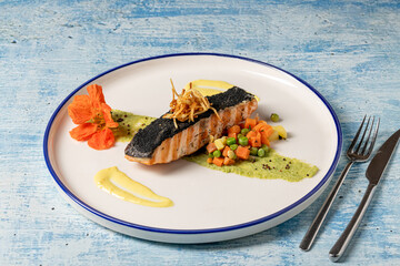 Grilled salmon fillet served with vegetables and gourmet garnish