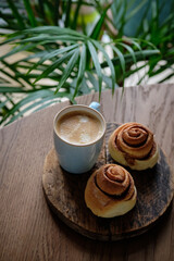 Tasty cinnamon rolls, sticks and nuts on table, closeup