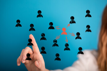 Image depicting a hand selecting a central figure from a group, symbolizing leadership, teamwork,...