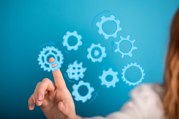 Abstract image of a hand interacting with gears, symbolizing workflow, process, and teamwork.