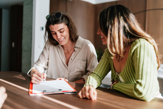 Real estate agent with couple signing contract during apartment visit