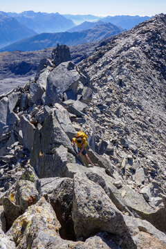 Alpinista in azione sulla cresta rocciosa tra il Pizzo Scop&igrave; e il Piz Miez, Lucomagno, Svizzera