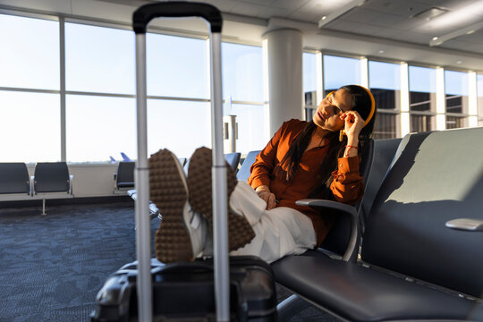 Businesswoman relaxing with headphones in airport terminal