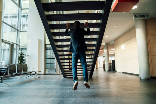 Confident business senior keeps fit with back training during office break