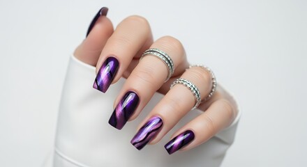 Close up of a woman's hand with long square purple magnetic gel nail polish and sparkling silver rings against a white background Manicure Nails Beauty Fashion Glamour Elegance Luxury