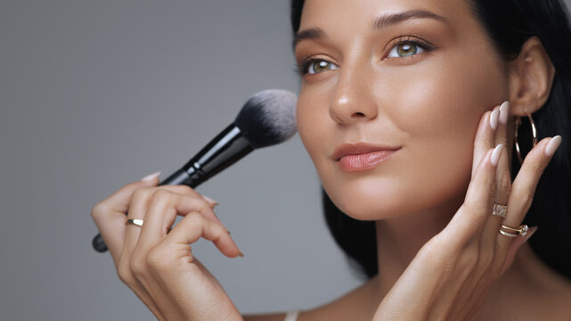 Glamorous Woman Highlighting Cheeks With Makeup Brush