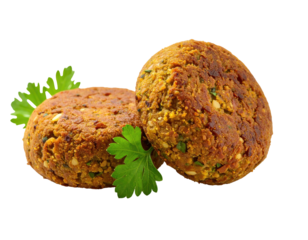 Two falafel balls, golden brown, resting on fresh parsley