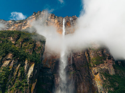Aerial view of Angel Falls cascading down the steep cliffs, partially obscured by clouds, in a dramatic display of nature's power, Canaima National Park, Bol&Atilde;&shy;var, Venezuela.