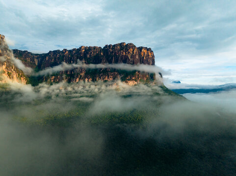 Aerial view of the imposing Tepui mountain rises majestically, shrouded in ethereal mist, a testament to nature's grandeur, Canaima National Park, Bol&Atilde;&shy;var, Venezuela.