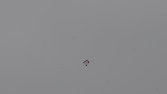 Single kite flying high in clear sky during Indian festival, minimal composition