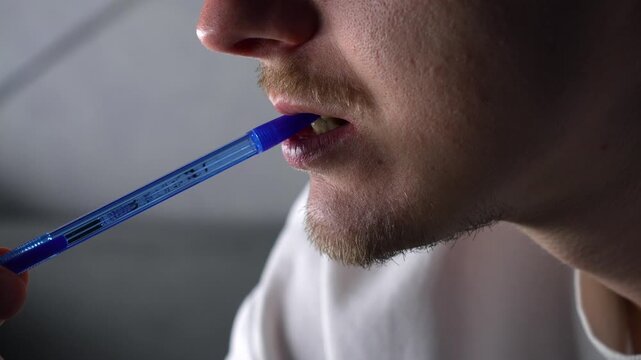 A writer is thinking about a book's script or plot and nervously chewing on his pen.
A person bites a pen with his teeth and thinks about the idea and plot of a book.