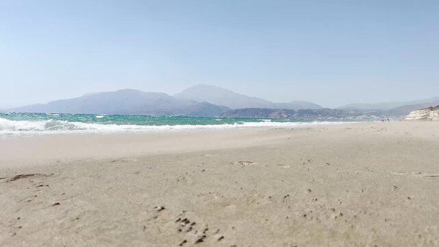 Video sul bagnasciuga della spiaggia di Kalamaki a Creta, con un vento forte che solleva la sabbia