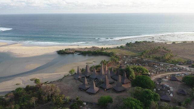 Aerial drone footage of the village of Ratenggaro with the traditional houses and beautiful sea coast during sunset at the western site of Sumba island, Indonesia