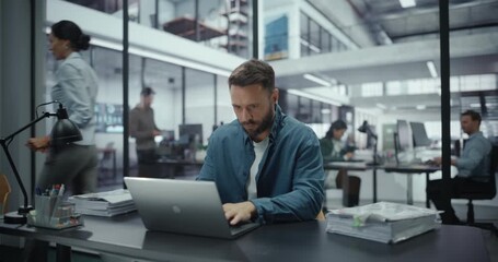 Young Stressed Specialist Using Laptop Computer in Modern Office. Overworked Tired Employee Dealing with Hard Work Tasks. Female Manager Bringing Another Folder with Documents to His Table - Powered by Adobe