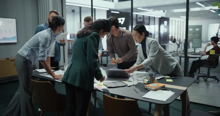 Diverse Professionals Engage in a Collaborative Office Setting, Discussing Project Strategies Around a Table with Computers and Reports on Papers. Team Focuses on Creative Solutions and Teamwork - Powered by Adobe