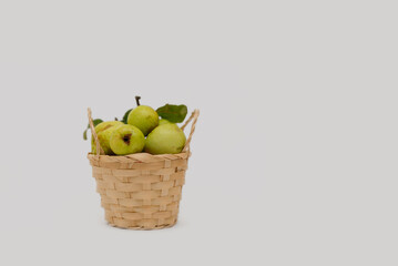 Green apples in a basket on a white background with space for text, selective focus