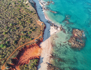 Aerial view of red rock against turquoise blue ocean. James Price Point, Western Australia. © Clare