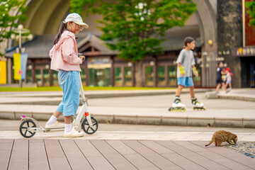  Asian girl is going to ride a scooter. Meerkat. Copy space