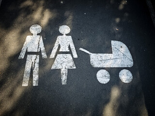 Symbols of family life on a city street, featuring parental icons and a stroller in a public area for children