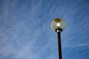 夕暮れ時に灯る丸い街灯