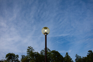 夕暮れ時に灯る丸い街灯