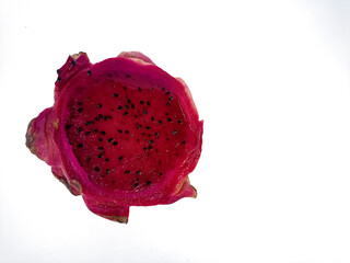 A close-up of a half dragon fruit shows the vibrant pink flesh with small black seeds. Isolated against a white background, it showcases the fruit's texture and color