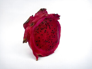 A close-up of a half dragon fruit shows the vibrant pink flesh with small black seeds. Isolated against a white background, it showcases the fruit's texture and color