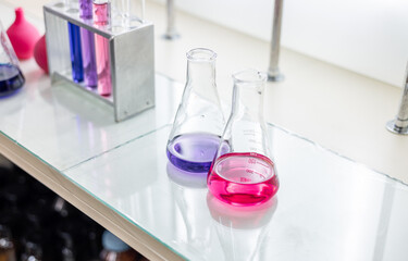 Laboratory analysis. Flask and test tubes on white table indoors, closeup. Laboratory test-tubes and retorts. Scientific equipment at laboratory.