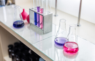 Laboratory analysis. Flask and test tubes on white table indoors, closeup. Laboratory test-tubes and retorts. Scientific equipment at laboratory.