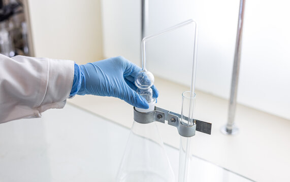 A female chemist assembles a device for distilling and absorbing arsenic in food products.