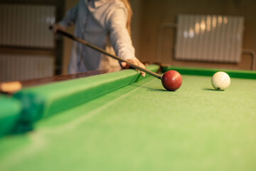 female hand collects colored balls after playing billiards and prepares a new game. Concept of spending free time with games