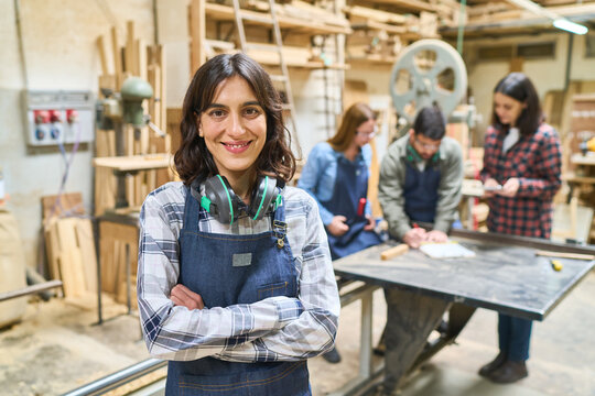Young woman in a busy lumberyard teamwork and apprenticeship session - Powered by Adobe