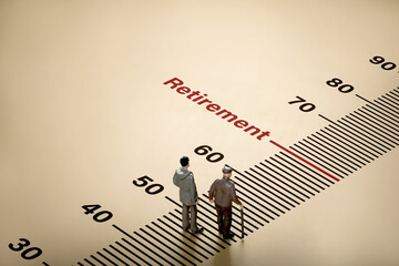 Word retirement age scale on background with little dolls of elderly businessman and young man....