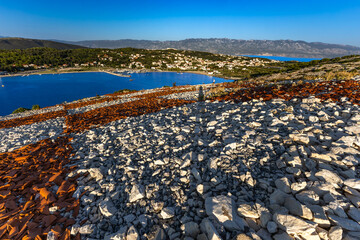 Rab the hill above the port in Lopar, the Croatian flag placed on a slope of red roof tiles,