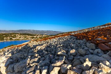Rab the hill above the port in Lopar, the Croatian flag placed on a slope of red roof tiles,