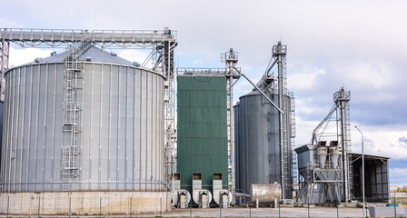 Modern steel agricultural grain granary silos. Agricultural silos for storage of grain harvest at an agricultural production farm.