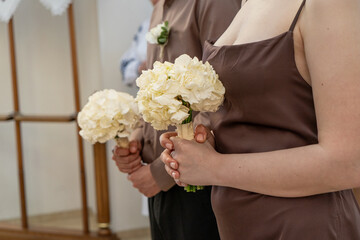 Wedding bouquet of white flowers in the hands of the bride