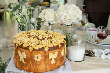 Traditional Ukrainian wedding bread korovai decorated with dough flowers and bows, symbolizing prosperity and unity, served on an embroidered ritual towel