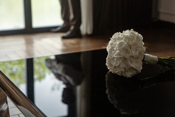 Wedding bouquet of white flowers on a black glass table