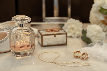 Wedding accessories rings, shoes and perfume on a table